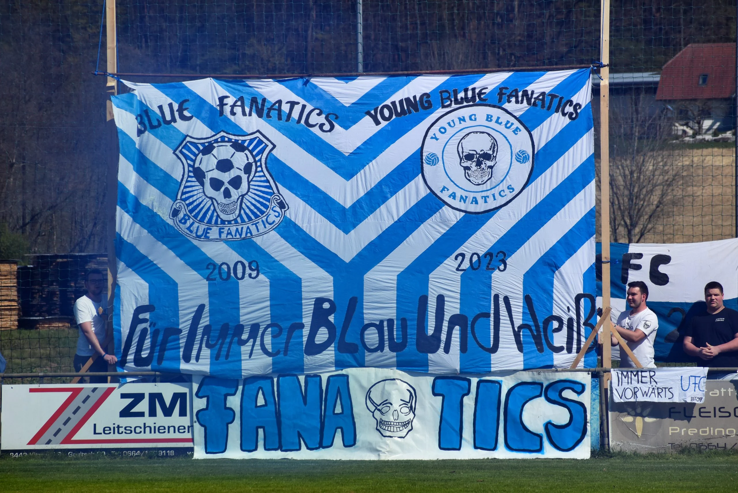 Große blau-weiße Fahne der Young Blue Fanatics mit dem Spruch „Für immer Blau und Weiß“